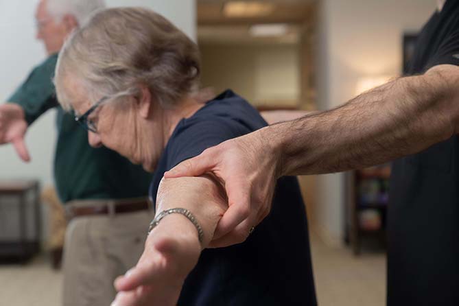 Nurse assists patient during physical therapy session