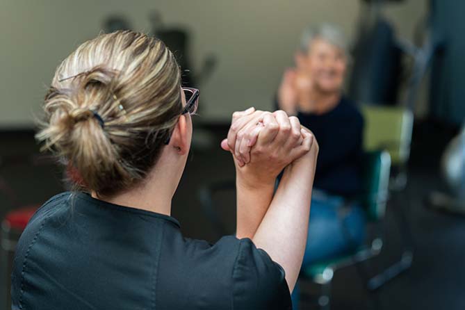Nurse instructs patient during physical therapy session