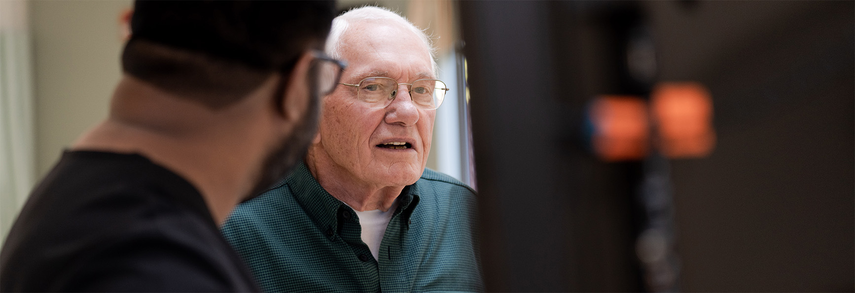 Older male patient interacting with clinical staff